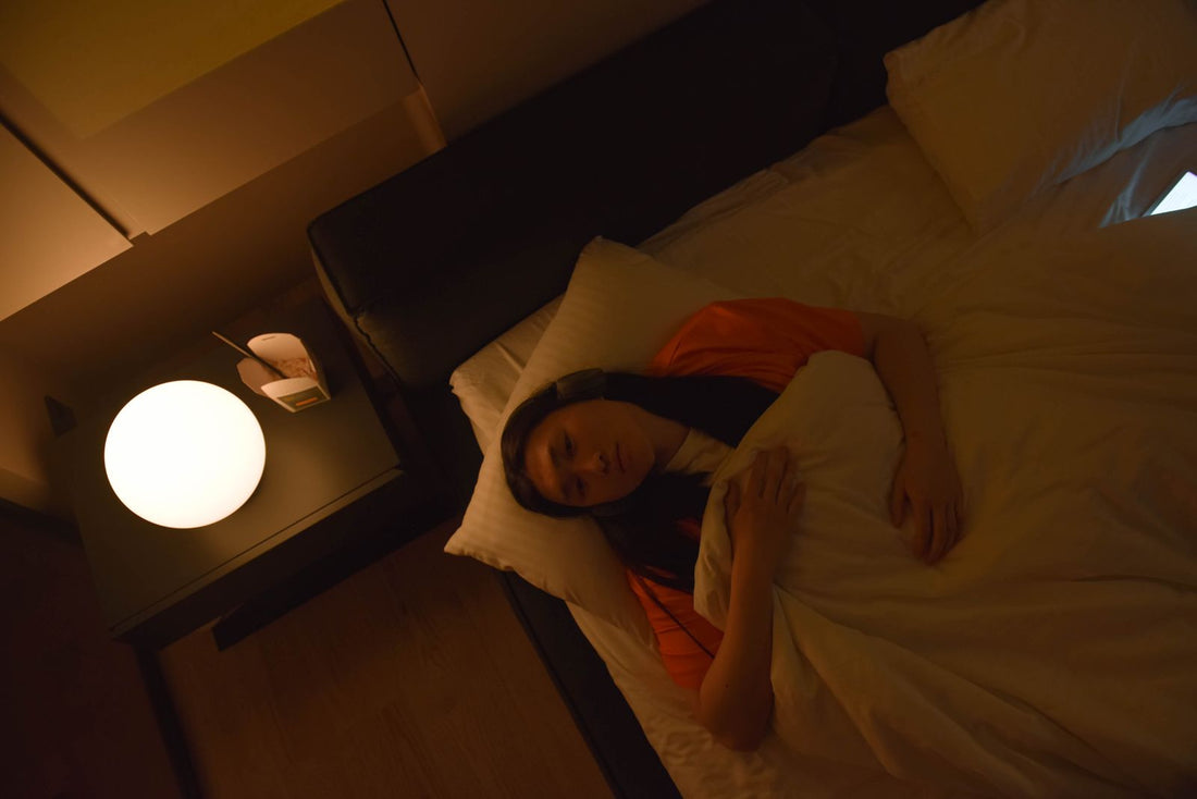 Woman lying awake in a dark bedroom in the early hours, unable to fall back asleep at 3am