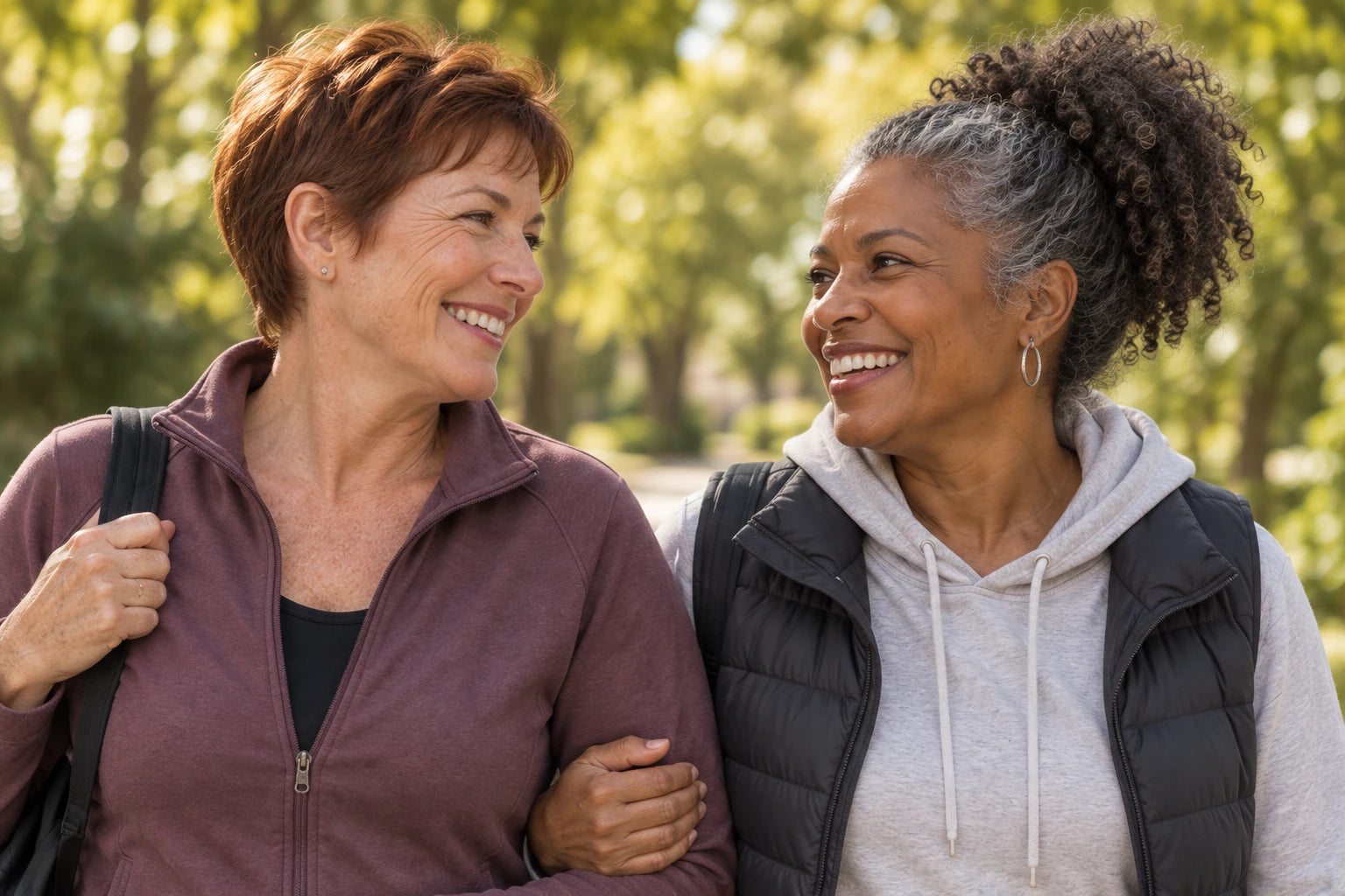 Two friends laughing together on a sunny neighborhood walk